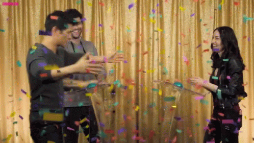 Group Standing Before Curtain With Confetti