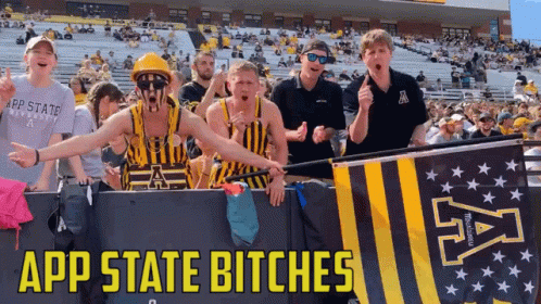 Group Standing in Front of App State Bitches Banner
