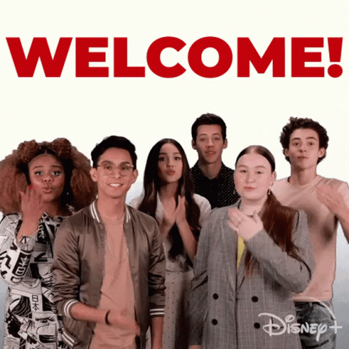 Group Standing In Front Of Welcome Sign GIF