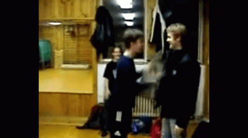 Group Standing in Room With Adidas Shirt