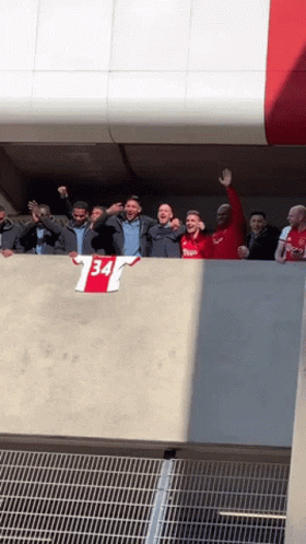 Group Standing on Balcony With 34 Shirt