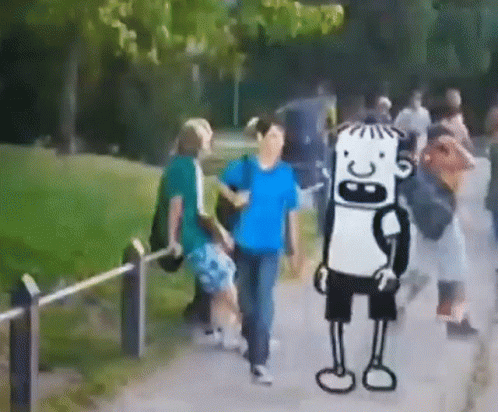 Group Walking Down Path With Cartoon Character in Background