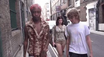 Group Walking Down Street With Man In Tiger Print Shirt GIF