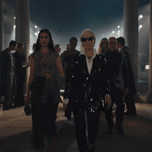 Group Walking in Dark Room With Columns