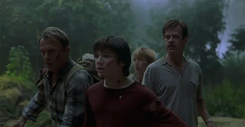 Group Walking In Forest With Dinosaur Emerging From Fog GIF
