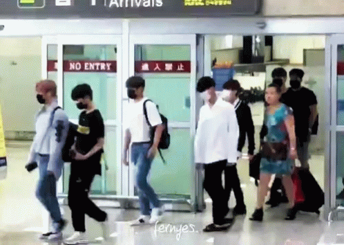 Group Walking Through Airport With No Entry Sign