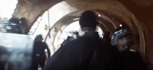 Group Walking Through Building Tunnel