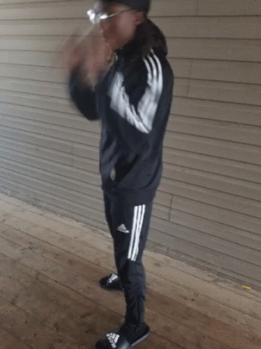 Guy Holding Glasses Wearing Black Adidas Suit GIF