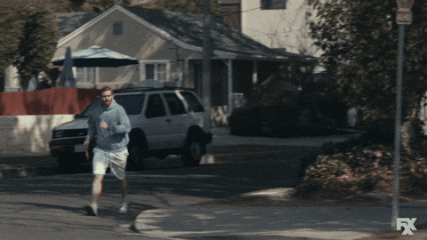 Guy Walking Fast On Roadside GIF