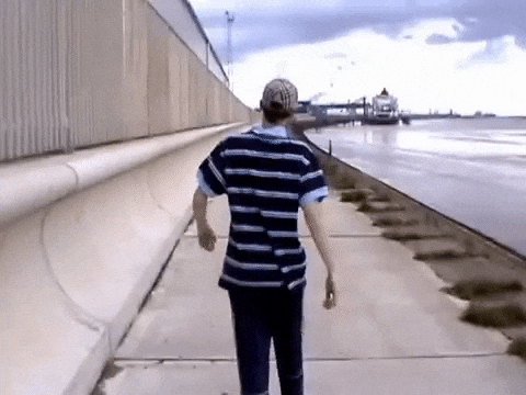 Guy Walking On A Promenade GIF