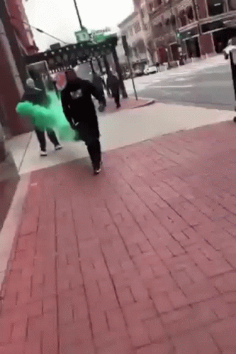 Guy Walking With Green Smoke Behind Him GIF