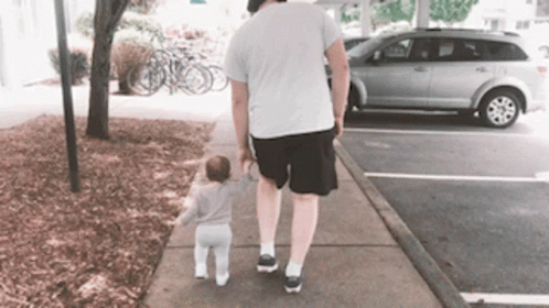 Guy Walking With His Baby On The Sidewalk GIF