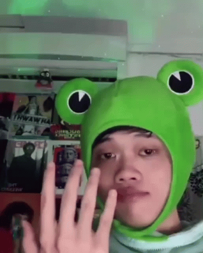 Guy Wearing Keroppi Cap With Finger Heart Sign GIF