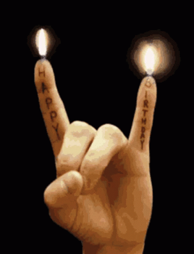 Hand Making Rock and Roll Sign With Candles