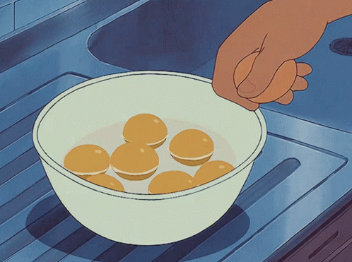 Hand Reaching Into Bowl of Yellow Balls