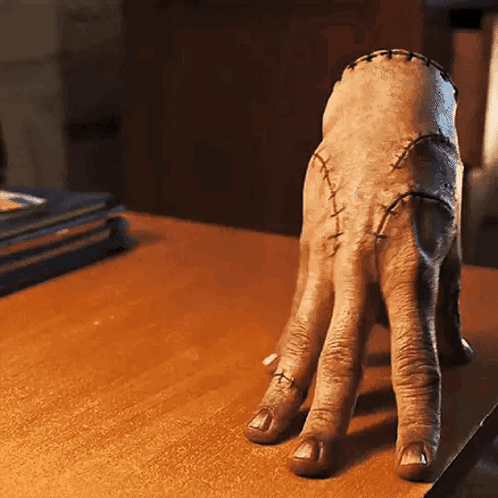Hand with Stitches on Wooden Table
