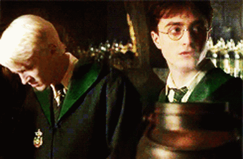 Harry Potter And Draco Malfoy Are Standing Next To Each Other In A Dark Room GIF