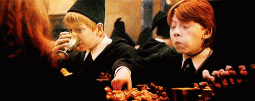 Harry Potter And Ron Weasley Are Sitting At A Table Eating Food And Drinking . GIF