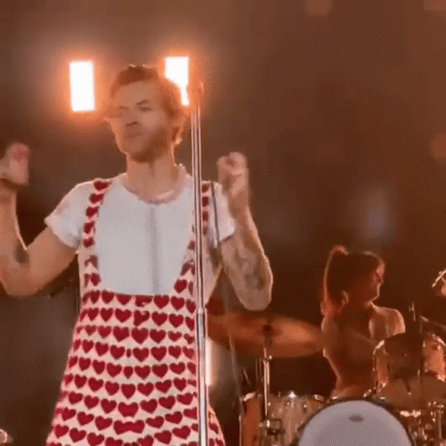 Harry Styles in Red and White Heart Dress at Microphone