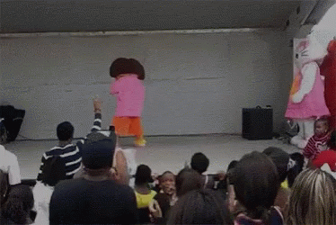 Hello Kitty And Dora The Explorer Are Dancing In Front Of A Crowd Of People GIF