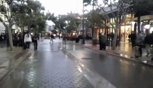 Hilarious Man Sprinting On Wet Street GIF