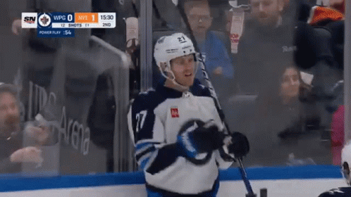 Hockey Player Holding Stick in Front of Crowd