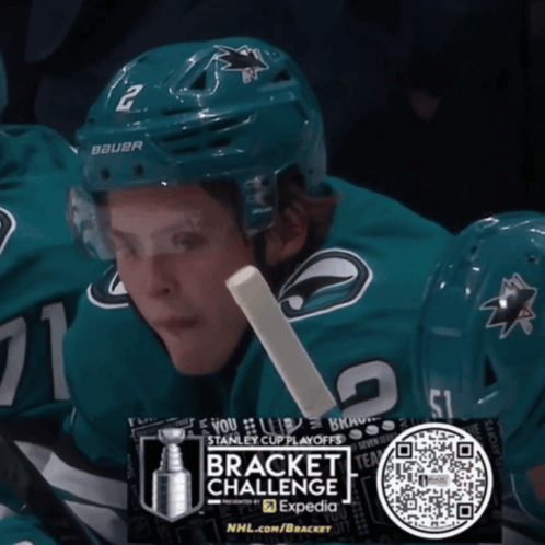Hockey Player in Bauer Helmet Holding Stick