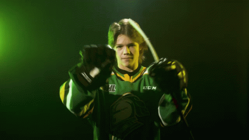 Hockey Player in Green and Yellow CCM Jersey Holding Hockey Stick