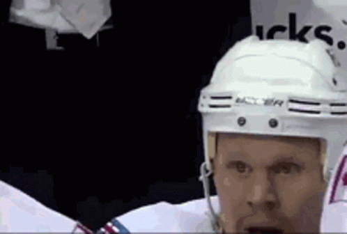 Hockey Player in White Helmet Standing in Locker Room