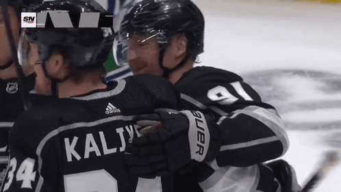 Hockey Player Kalij Hugging Another Player