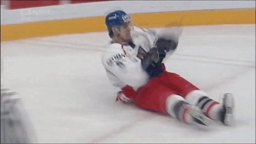 Hockey Player Lying on Ice in Blue Helmet