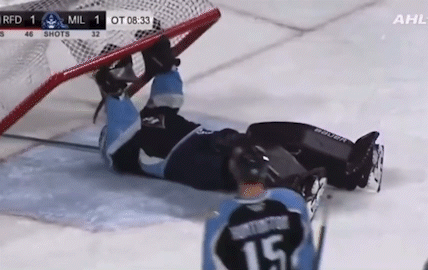 Hockey Player Lying on Ice in Front of Goal