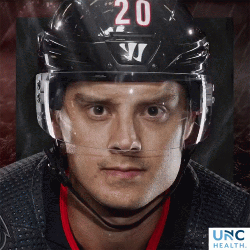 Hockey Player Number 20 on Helmet Looking at Camera