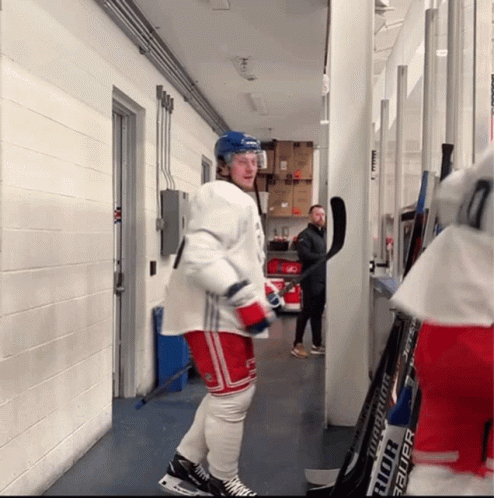 Hockey Player Standing Next to Bauer Stick