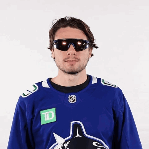 Hockey Player Wearing Sunglasses and Blue Jersey