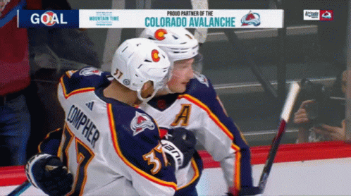 Hockey Players Hugging in Front of Avalanche Ad