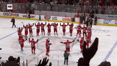Hockey Players On The Ice In Front Of A Banner That Says Discover GIF