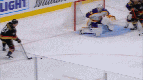 Hockey Players On The Ice With A Light Advertisement In The Background GIF