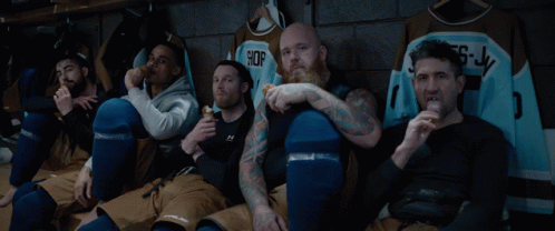 Hockey Players Sitting in Locker Room