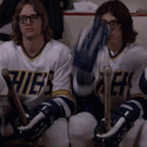 Hockey Players Sitting on Bench One Covering Face
