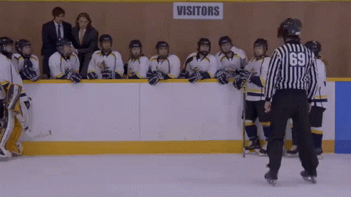 Hockey Players Standing in Front of Visitors Sign