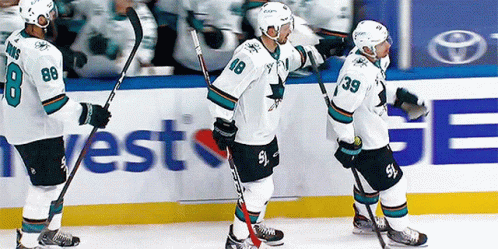 Hockey Players Standing on Ice With West Ge Ad