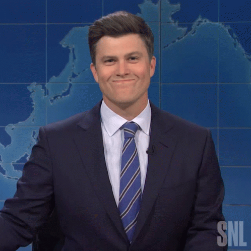 Holding In Laugh Colin Jost As Newscaster GIF