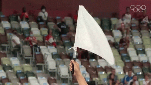 Holding White Flag in Stadium with Olympic Rings