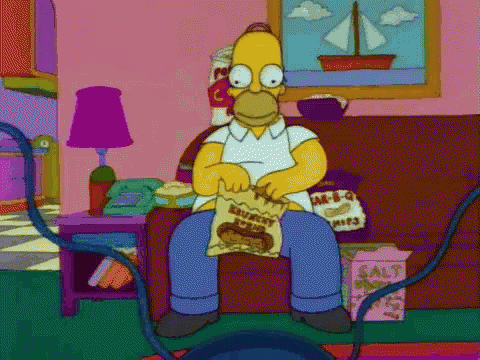 Homer Simpson From The Simpsons Is Sitting On A Couch Eating A Bag Of Chips . GIF