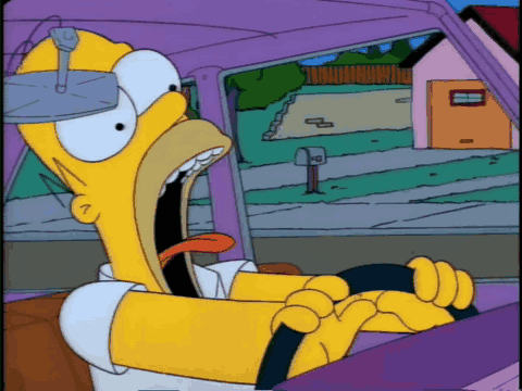 Homer Simpson Is Driving A Car With His Mouth Open And His Tongue Sticking Out GIF