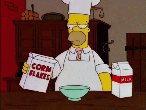 homer simpson is reading a box of corn flakes