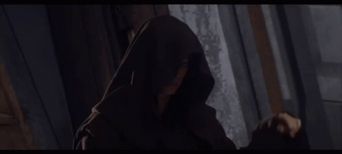Hooded Person Standing in Darkness
