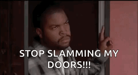Ice Cube Is Standing In A Doorway With His Hand On The Door . GIF