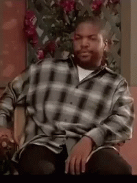 Ice Cube Sitting in Chair Wearing Plaid Shirt Smoking Cigarette